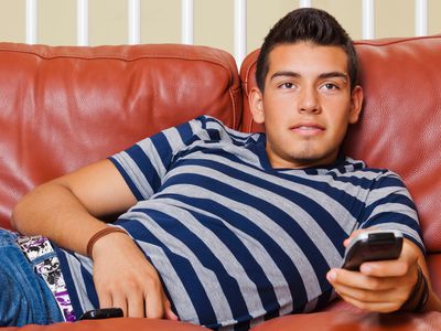 A college student watching TV in a dorm room