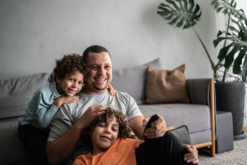 Father and sons watching TV at home