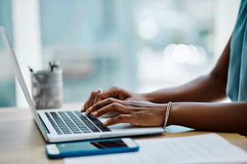 Closeup of someone typing on a laptop keyboard.