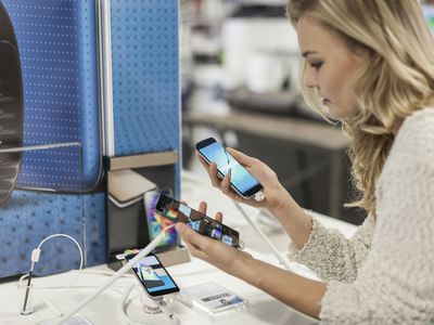 A woman comparing two smartphones in a store