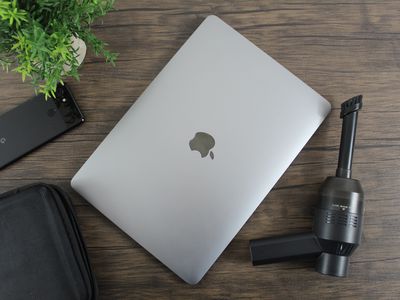 A MacBook with cleaning tools.