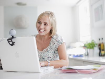 Smiling woman enjoying video chat on laptop